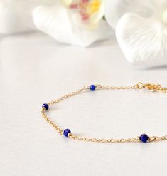 This beautifully simple bracelet is lovingly handmade with a six tiny Lapis Lazuli gemstones and a choice of 14k Gold Filled, 14k Rose Gold Filled or Sterling Silver Chain. M A T E R I A L S: * Lapis Lazuli * 14k Gold Filled, 14k Rose Gold Filled or Sterling Silver Chain S I Z E: *  Gemstones - Approximately 2-3mm *  Chain Thickness - Approximately 1.1mm  All of our jewellery is carefully handmade using good quality materials and handpicked gemstones, with the aim to produce quality pieces that you can love & wear for years to come.  L A P I S  L A Z U L I: * September Birthstone * Talisman for Taurus, Virgo, Libra, Sagittarius * Throat Chakra, Third Eye Chakra A stone of protection, Lapis Lazuli quickly releases stress, bringing deep peace. It brings harmony and deep inner self-knowledge. Tiny Beads Bracelet Jewelry Gift, Elegant Blue Chain Bracelet As Gift, Elegant Blue Chain Bracelet For Gift, Delicate Blue Bracelets For Everyday, Blue Dainty Birthstone Bracelets, Gold Lapis Lazuli Bracelets For Gift, 14k Gold Chain Bracelet With Round Beads, 14k Gold Chain Bracelet With Round Beads Gift, Blue Birthstone Dainty Jewelry