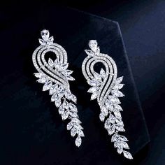 A delightfully unique pair of bridal earrings with an incredible sparkle! Lightweight, the earrings are adorned with flawlessly faceted cubic zirconia that capture the light in a dazzling array of sparkles. Rhodium plated for a bright finish which enhances the intricate detailing and conveys a modern take on old elegance. Available in two sizes - Large and Small. To make your choice select your preferred length from the dropdown menu to add to cart. Large: Length: 3.2" (approx. 8.1cm); Width: 0. Exquisite Diamond White Crystal Earrings, Diamond White Cubic Zirconia Bridal Earrings For Party, Dazzling Cubic Zirconia Bridal Earrings For Evening, Diamond White Cubic Zirconia Chandelier Earrings For Party, Glamorous Cubic Zirconia Diamond Earrings With Sparkling Stones, Glamorous Diamond Earrings With Sparkling Stones, Glamorous Cubic Zirconia Chandelier Earrings For Anniversary, Glamorous Diamond White Cubic Zirconia Earrings, Glamorous Bridal Earrings, Diamond With Brilliant Cut