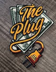 the plug logo on a wooden surface with money coming out of it and an orange wrench