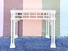 a white table sitting in front of a colorful wall