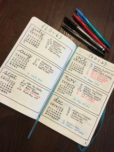 an open notebook with calendars and pens on it