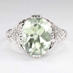 This vintage style ring features a prasiolite (green amethyst) set in a sterling silver setting. The Art Deco style setting is beautifully crafted with lattice-like filigree. The prasiolite is a natural, earth mined stone. The ring measures 13mm across (north south) and 7mm from finger to top. Please note that colors can vary slightly depending on your monitor and display settings. An appraisal is available upon request. All of our pieces come with a 30 day return policy and 100% satisfaction gu Amethyst Set, Vintage Style Rings, Art Deco Stil, Ring Art Deco, North South, Green Amethyst, Natural Earth, Deco Style, Eternity Bands