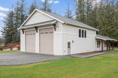 a two car garage sits in front of some trees