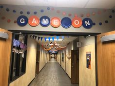 a hallway with balloons and streamers on the ceiling for game room party decorating