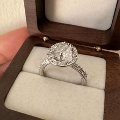 a diamond ring is in a wooden box