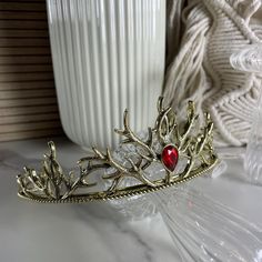 Throne of Glass inspired crown of Aelin Galathynius, Lord of the North. Fireheart crown with red stone and golden antlers. Circumference approx. 15 cm For MORE SELECTION and better offers please visit our website https://chest-of-fandoms.de/shop/bookish-merch/. Instagram @chestoffandoms TikTok @chestoffandoms Antler Crown, Aelin Galathynius, Throne Of Glass, Red Stone, Antlers, Wedding Hair Accessories, Tiara, Jewelry Inspiration, Crown