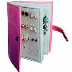 an open pink and white box with earrings on it's sides, in front of the caption