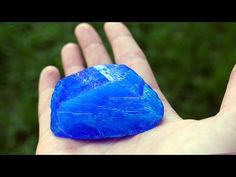 a hand holding a blue rock in it's palm