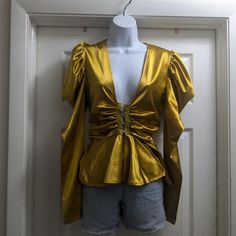 This Gold Colored Satin Top Has Long Sleeves It Has A Poofy Part At The Top Of The Sleeve It Has A Wide Deep V-Neck It Has Clasps Around The Top Of The Waist With A Ruffle On The Bottom Part.. This Is Brand New With Tags It's A Beautiful Shirt On.. Great For Girls Night Out Or Your Date Night Or Anytime You Want ..The Size Is Small Padded V-neck Blouse For Night Out, Glamorous V-neck Blouse For Fall, Glamorous V-neck Blouse For Summer, Glamorous V-neck Summer Blouse, Gold V-neck Summer Blouse, Glamorous Padded Blouse For Spring, Summer Gold Padded Blouse, Long Sleeve Gold Blouse For Summer, Gold Padded Blouse For Summer