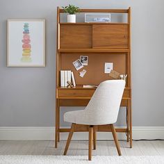 a desk with a chair next to it and a shelf on the wall behind it