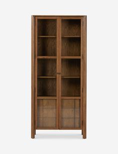 an oak bookcase with glass doors on the top and bottom shelves, in front of a white background