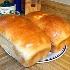 two loaves of bread sitting on a white and blue plate in front of a wooden counter