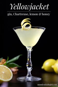 a glass filled with lemonade sitting on top of a table next to lemons