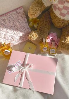 two brown teddy bears sitting next to each other on a bed with pink and white sheets