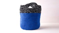 a crocheted blue and black bag on a white background