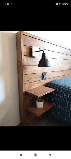 a bed room with a neatly made bed and a wooden head board on the wall