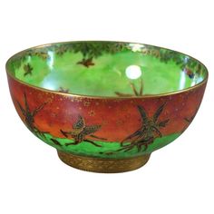 a green and red bowl with birds on it