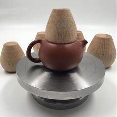 a tea pot sitting on top of a saucer next to wooden spoons and cups