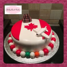 a cake decorated with an airplane and the flag of canada on it's side