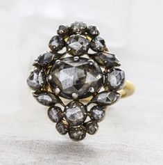 An original antique Georgian style diamond ring circa 1850's. This delightful treasure reflects light beautifully. The diamonds are foil backed set in a silver top and gold bottom. This item has no sign of change or repair. Details: SIZE: 4 Antique Diamond Ring Silver Top / Gold Bottom Original Condition No Sign Of Change Or Repair Foil Backed Diamonds Total Carat Weight: Approx. 3 carats Center Oval Diamond Total Carat Weight: 2 carats 4 Marquise = 0.40ct /4Round=0.45 /4Round=0.20ct /6Round=0.1 Antique Cluster Ring With Rose Cut Diamonds, Victorian Diamond White Ring With 17 Jewels, Victorian Style Diamond Ring With Diamond Cut, Victorian Diamond Cluster Ring, Victorian Style Diamond White Rose Cut Diamond Ring, Antique Cluster Ring With Diamond Accents, Victorian Cluster Ring With Diamond Accents In Diamond White, Victorian Oval Diamond Ring With Rose Cut Diamonds, Antique Marquise Rose Cut Diamond Ring