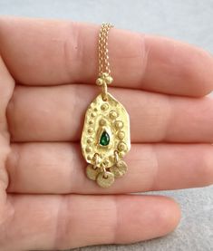 Boho gold necklace 9k 14 k Solid gold necklace with green emerald May birthstone, Yellow gold necklace, Delicate Pendant, Gift for her This solid gold necklace has a rustic textured and is set with a natural green emerald. The pendant has a delicate granulation all around it. This pendant is delicate but has a lot of character, and will upgrade any outfit you'll wear, for everyday use, as for special occasions The pendant can be ordered without the chain too. An excellent choice for anniversary Fine Jewelry Gold Emerald Necklace With Delicate Chain, Gold Emerald Necklace With Delicate Chain, Fine Jewelry, Gold Plated Emerald Necklace As A Fine Jewelry Gift, Yellow Gold Delicate Chain Necklace For May Birthstone, Gold Emerald Necklace With Round Birthstone, Dainty Gold Emerald Birthstone Necklace, Yellow Gold Emerald Necklace With Round Pendant, Gold Emerald Necklace With Delicate Chain For Gift, 17 Jewels Gold Plated Emerald Necklace As Gift