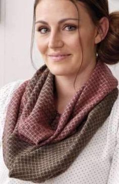 a woman wearing a scarf and smiling at the camera with her hair in a bun