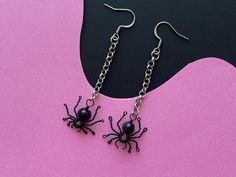 Unleash your edgy side this Halloween with our Spider Earrings, featuring a unique blue sandstone bead for a touch of dark elegance. Perfect for lovers of goth jewelry, these crawler bug earrings are both creepy and stylish, making them the ultimate statement piece for any spooky occasion. Whether you're embracing your inner goth or looking to add a twist to your Halloween look, these earrings are sure to make an impression. Dimensions; around 7.5 cm long (including findings) Each pair of earrings is meticulously handcrafted with artisans skills using the finest of materials like Gold pleated Stainless Steel or Brass for the metals in this case black coated copper wire. From the initial design concept to the final detail, every step of the process is executed with precision and care to ens Themed Black Metal Jewelry, Spooky Adjustable Black Jewelry, Emo Metal Earrings For Gift, Adjustable Black Spooky Jewelry, Punk Style Halloween Jewelry Gift, Emo Style Metal Earrings For Gift, Black Novelty Jewelry For Gifts, Edgy Handmade Jewelry Gift, Handmade Edgy Jewelry For Gifts