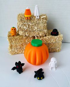 some toys are sitting in front of hay bales with pumpkins and ghost figures