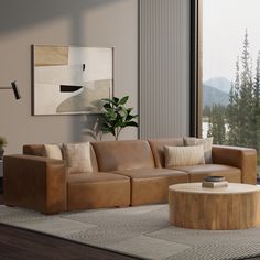 a living room filled with furniture and a large window overlooking the mountain range in the distance