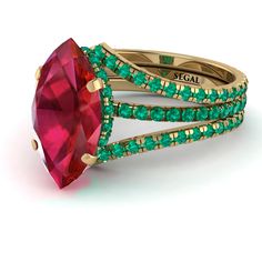 a ring with green and red stones on it's sides, set against a white background