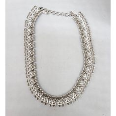 This is part of Chairish’s Costume Jewelry assortment.  1960s rhodium plated textured openwork articulated collar necklace with hook clasp. Marked "Monet" on a hangtag and "©" on the opposite side of the tag. Measures: 5 1/4 inches by 5 1/4 inches. Interior circumference on the largest setting is about 15 inches. Condition: Very good; it may have originally had a dangle at the end of the extension chain. Silver Chain Choker For Formal Occasions, Vintage Silver Adjustable Chain Necklace, Silver Metal Chain Necklace For Evening, Silver Costume Jewelry Choker, Evening Metal Choker Chain Necklace, Silver Metal Choker For Evening, Formal Silver Metal Chain Necklace, Retro Silver Metal Necklaces, Retro Silver Metal Necklace