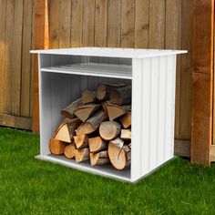 a stack of firewood sitting inside of a white storage box on top of green grass