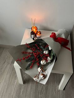 a table topped with candles and flowers on top of a wooden floor next to a wall