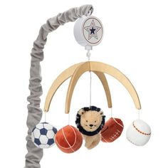 a teddy bear hanging from a wooden mobile with balls on it's back end