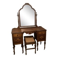 an antique wooden dressing table with mirror and stool