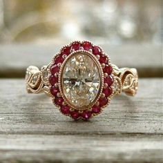 a close up of a ring with a diamond and garnets on the side