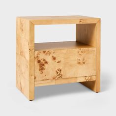 an unfinished wooden side table with one drawer open and the bottom section partially covered in wood