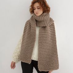 a woman wearing a brown and white knitted sweater with a scarf around her neck