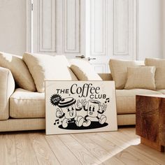 a coffee sign sitting on top of a wooden floor next to a couch and table