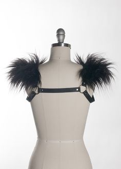 This chest harness with faux fur shoulder detail adds instant gothic drama and impact to any outfit. This piece works especially well with dresses and flowing tops that don't have a defined waistline, or paired with a corset. Buckles in front across chest. Silver toned nickel-plated steel hardware. Shown in black leather. Also available in PVC. All colors have black faux fur except white PVC, which has white faux fur.All pieces are MADE TO ORDER, standard sizes XS-4XL. If your measurements fall Gothic Party Harness With Straps, Fitted Punk Harness For Alternative Fashion, Gothic Harness For Cosplay, Edgy Fitted Harness For Alternative Fashion, Black Fitted Gothic Harness, Gothic Black Harness With Straps, Black Gothic Harness With Straps, Gothic Fitted Harness For Party, Black Gothic Harness For Cosplay