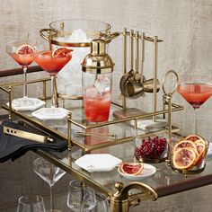 a table topped with glasses filled with different types of drinks and garnishes