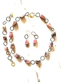 I handcrafted this unique set of three items from 100% large natural rhodonite with a modern cut and black-colored steel hardware.  The short necklace, measuring 40 cm, combines the femininity of rhodonite with the boldness of black rings.  The necklace features a spring ring clasp, completing the composition of pink, black, and gold colors.  The bracelet has a toggle clasp and an extension chain for easy fastening.  The earrings have stainless steel ear wires. The set is hypoallergenic and envi Rose Noir, Gold Colors, Rose Black, Black Necklace, Short Necklace, Birthday Gift Ideas, Black Rings, Necklace Earrings, Spring Rings