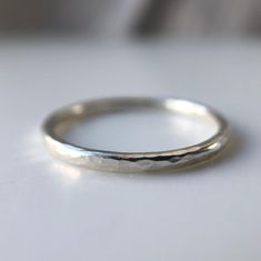 Galene - Greek Goddess of Calm Waters and Tranquillity. This Beautiful extra fine recycled silver band is perfect for stacking and looks equally beautiful as a stand alone ring. The soft organic hammered texture is inspired by reflections in calm water and creates a gorgeous shimmer in the light. Each ring is handmade to order by me from my workshop in Brighton. The delicate texture is hand applied making each ring completely unique in its beauty.  The ring is 1.5mm in width and is made using 10 Striling Silver Rings, White Gold Minimalistic Silver Ring, Silver Rings Basic, Silver Rings Handmade Minimalist, Brighton Rings Sterling Silver, Silver Stacking Ring, Silver Liquid Ring, Textured Wedding Band, Alternative Wedding Bands