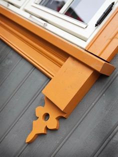 an orange window seal on the side of a house with a white window in the background