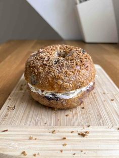 a bagel sitting on top of a wooden cutting board