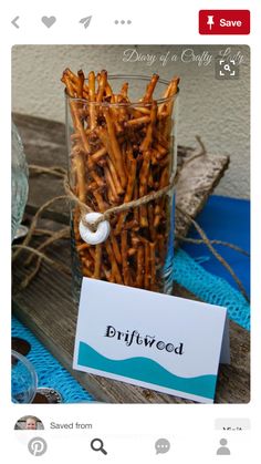 a jar filled with fries sitting on top of a wooden table next to a sign