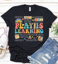 a black t - shirt with the words play is learning on it