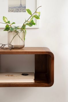 a wooden shelf with a plant and glasses on it