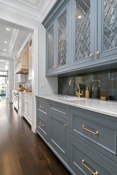 a kitchen with gray cabinets and gold handles on the countertops, along with an iphone app