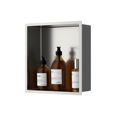 three bottles of soap and lotion sitting in a metal box on a white background